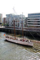 Sailing ship on Elbe River passing in front of HafenCity. Hamburg, Germany.