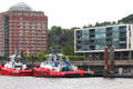 Modern architecture & working tug boats on Elbe River in Altona borough. Hamburg, Germany.