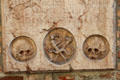 Tombstone with skulls & crossbones mounted on wall of Frauenkirche. Munich, Germany.