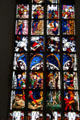 Modern stained glass window features martyred saints at Frauenkirche. Munich, Germany.