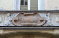 Relief carving of street scene flanked by sphinxes on Pfisterstaße. Munich, Germany.