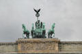 Four horses of quadriga of Victory atop Brandenburg Gate. Berlin, Germany