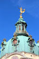 Golden statue atop baroque tower dome at Charlottenberg Palace. Berlin, Germany.