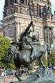 Amazon on Horseback bronze statue by August Kiss at Altes Museum seen against Berlin Cathedral. Berlin, Germany.