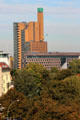 Commercial buildings marked by tower topped by green cube over Karlsbad Park. Berlin, Germany.