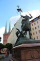 St George Slaying The Dragon sculpture with St. Nicholas' spires beyond in Nikolaiverteil. Berlin, Germany.