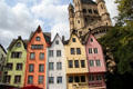 Colorful restored historic dwellings of Fischmarkt area with tower of Great St. Martin church in background. Köln, Germany.