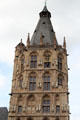 Figure carvings and golden clock on Gothic tower of Cologne City Hall. Köln, Germany.