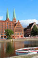 Heritage buildings along Holsten Hafen with St. Mary's church beyond. Lübeck, Germany.