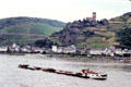 Barge traveling along Rhine River with Gutenfels castle in background. Kaub, Germany.