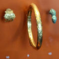 Gold arm & finger rings + bronze decorative pin with face at Trier Archaeological Museum. Trier, Germany.