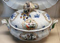 Meissen porcelain terrine with putto angel holding cornucopia lid handle & painted with birds plus blue foliage at Meissen porcelain museum at Lustheim Palace. Munich, Germany.
