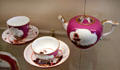 Meissen porcelain purple cups & saucers plus teapot with Asian scenes painted in white quatrefoils at Meissen porcelain museum at Lustheim Palace. Munich, Germany.