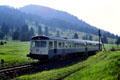German country train rolling through hills & green valley. Germany.
