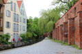 Brick Memmingen city wall beside canal & residential buildings. Memmingen, Germany.