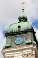 Cross with golden sunburst atop clock tower at Ettal Benedictine Abbey. Ettal village, Germany.