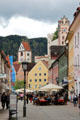 Main pedestrian zone along with wooded hills & Hohes Schloss tower in background. Füssen, Germany.