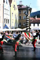 Entertainment on Old Town Square with Stadtbrunnen with St Magnus slaying dragon in background. Füssen, Germany.