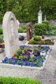 Tombstone & planted flowers in cemetery of St Aegidius parish church. Gmund am Tegernsee, Germany.