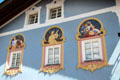 Windows trimmed with decorative plaster designs & paintings of local dress. Mittenwald, Germany.