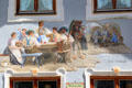 Tromp l'oeil painting of townfolk in local dress gathered together on building exterior. Mittenwald, Germany.