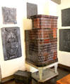 Ceramic tile stove surrounded by collection of German cast-iron fireplace shields at Lindau Municipal Museum. Lindau im Bodensee, Germany.