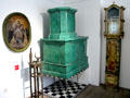 Tiled heating stove & painted tall clock by Georg Lang at Oberammergau Museum. Oberammergau, Germany.