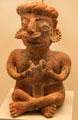 Colima culture ceramic sitting male figure holding fish from Western Mexico at Museum of America. Madrid, Spain.