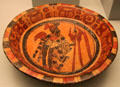 Mayan ceramic plate with figure holding spear beside jaguar ringed by glyphs from Mesoamerica at Museum of America. Madrid, Spain