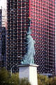 Statue of Liberty quarter-scale replica on Île aux Cygnes seen against red Novotel Paris Tour Eiffel. Paris, France.