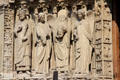 Saints carvings on left portal of Notre Dame Cathedral including St. Denis holding head. Paris, France.