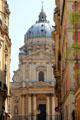 Baroque scroll & facade of Val-de-Grâce church seen from approaching street. Paris, France
