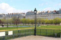 Fence & lamp post in Tuileries Garden with rue de Rivoli buildings beyond. Paris, France.