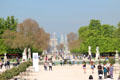 Sculptures surround Grand basin in Tuileries Garden with Obelisk & Arc du Triomphe beyond. Paris, France