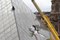 Washing the windows of Louvre Pyramid. Paris, France.