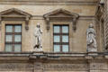 Statues of Voltaire & Bossuet on facade of Louvre Palace. Paris, France.
