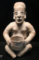 Terra cotta male statuette holding a vase from Jalisco, Mexico at Musée du quai Branly. Paris, France.