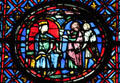 Seated king with men holding chalice stained glass scene at St Chapelle. Paris, France.