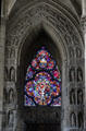 Stained glass window surrounded by niches with carved saints in Reims Cathedral. Reims, France.