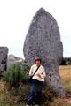 Visitor in front of megalith. Carnac, France.