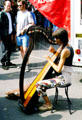 Woman playing harp at Carnac open air market. Carnac, France.