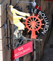 Restaurant sign of sailor at ship's wheel. St Malo, France.
