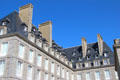 Building with dormers in steep roof & massive chimneys seen from ramparts. St Malo, France.
