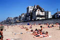 Bathers on beach with small hotel buildings beyond. St Malo, France.