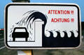 Sign warning of dangers of parking beside sea wall. St Malo, France.