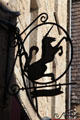 Sign with profile of unicorn along Grande Rue. Mont-St-Michel, France