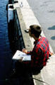 Artist sketching view of harbor. Concarneau, France.