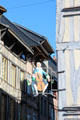Shop sign of cellist on half timbered building. Rouen, France.