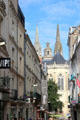 View of spires of St. Maurice Cathedral over shops of rue Saint-Aubin. Angers, France.