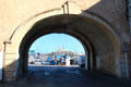View through city gate to harbor & mega-yacht. Antibes, France.